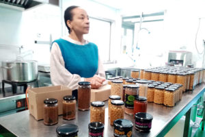 Edna Herrera en la cocina de Naturalmente Bio con una selección de productos en conserva