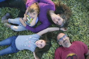 Rafael García, Begoña Barragan and their children lying on a bed of harvested olives