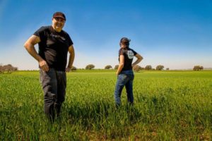 Arrate en Igor Corres staand in een veld met jonge tarwe