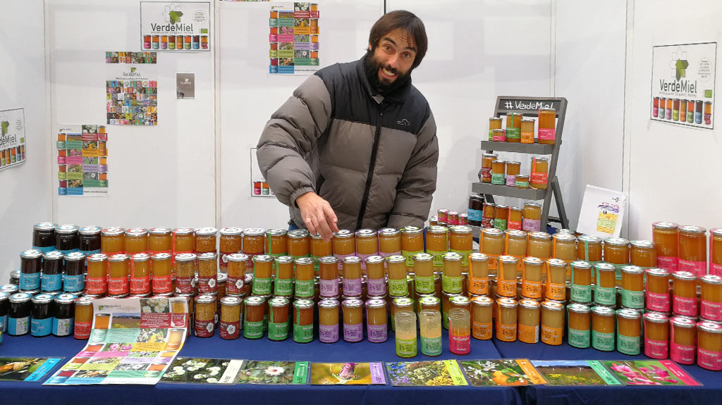 Antonio Carlos Calvo of beekeepers VerdeMiel, standing behind a table of honey jars