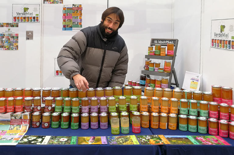 Antonio Carlos Calvo of beekeepers VerdeMiel, standing behind a table of honey jars