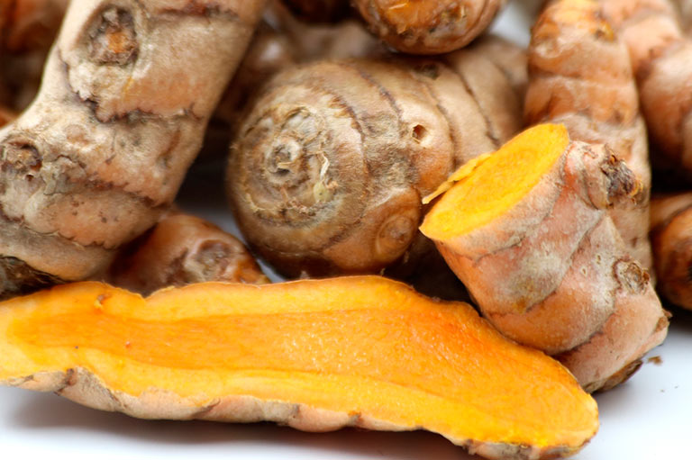 Close up photograph of whole and cut turmeric