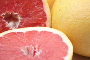 Close up photograph of whole and cut grapefruit