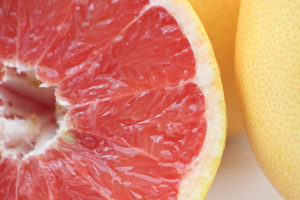 Close up photograph of whole and cut grapefruit
