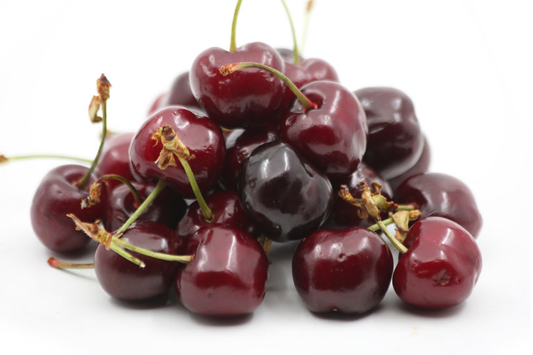 A group of deep red cherries