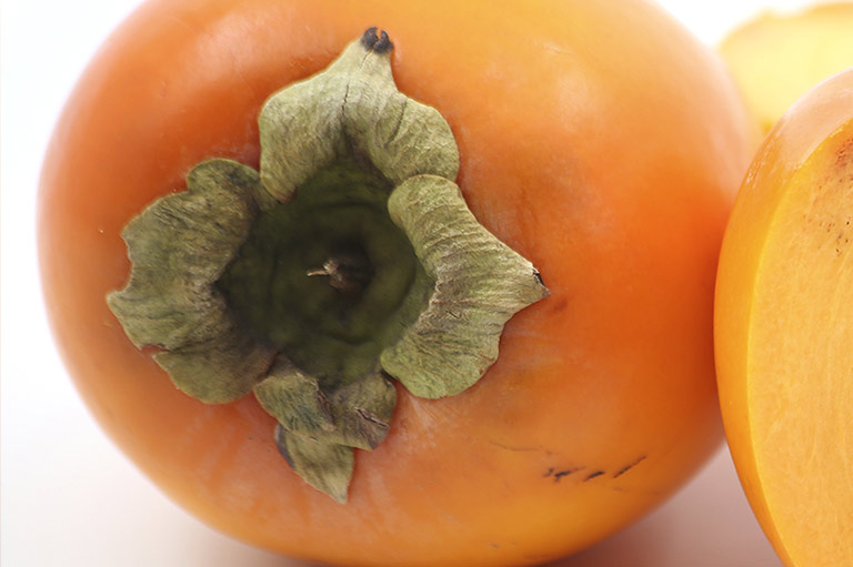Close-up van de kenmerkende stengel van een persimmonfruit