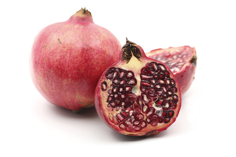 Two pomegranates, one of them cut in half