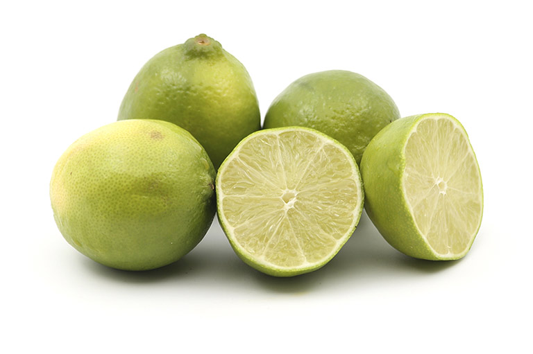 Un groupe de quatre citrons verts, dont un coupé en deux