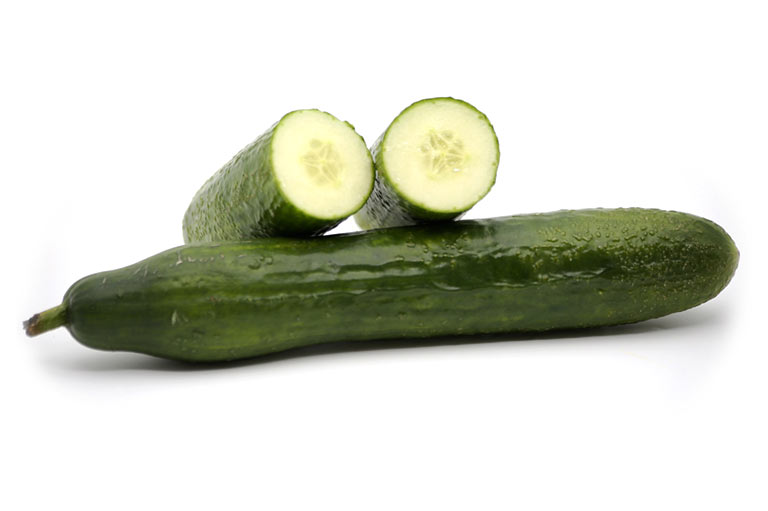 Twee komkommers, waarvan er één in tweeën is gesneden