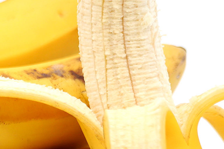 Close up of bananas, showing the peel and light yellow flesh inside