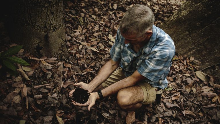 Jose González holding soil in his cupped hands