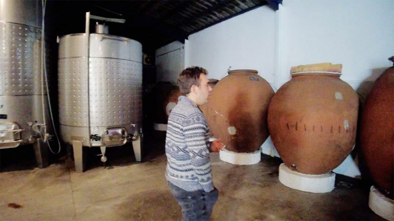 A warehouse containing both large metal wine vats and old clay amphoras