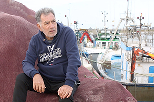 Fisherman Antonio Carillo, sitting on some fishing nets