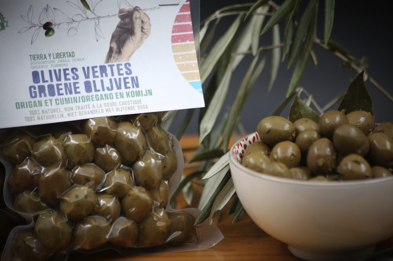 Un sachet d'olives sous vide, à côté d'un bol d'olives