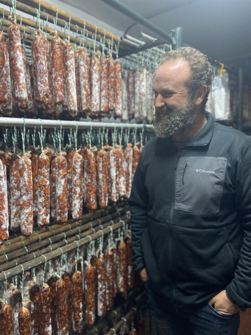 Antonio inspects his sausages in the drying room